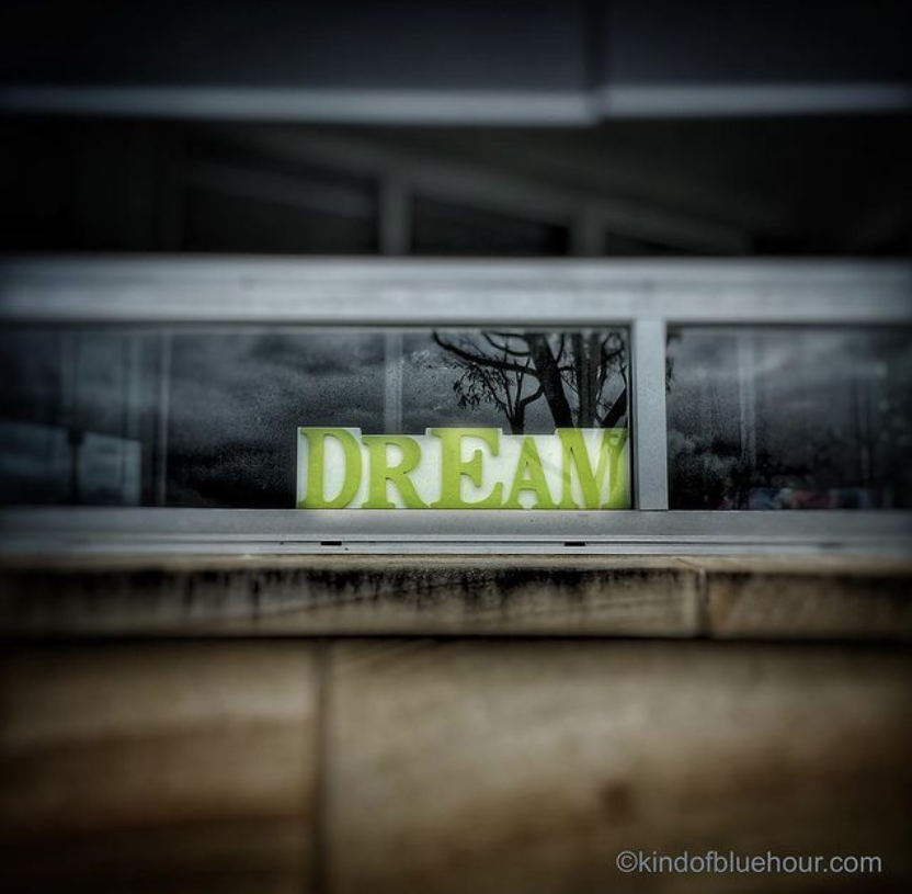 Green capital letters that spell out DREAM sit on a window sill. Photo by Patrick Wu