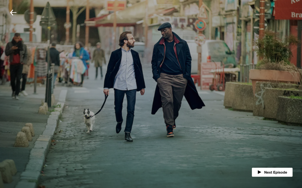 Assane Diop (Omar Sy) walks with friend Benjamin Ferel (Antoine Gouy) and their dog J'accuse